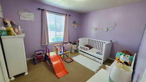Bedroom featuring baseboards and a nursery area