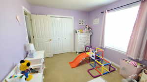 Bedroom featuring light colored carpet