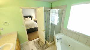 Ensuite bathroom with a stall shower, a tub with jets, and vanity