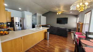 Kitchen featuring stainless steel fridge,  wood-style floors, a ceiling fan, vaulted ceiling, and a sink