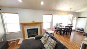 Living area with a fireplace, wood finished floors, baseboards, and recessed lighting