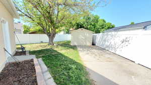 View of yard featuring a storage shed and rv parkign behind fence