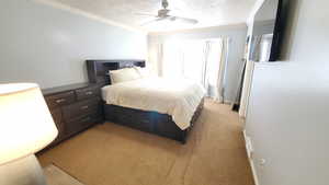 Bedroom with crown molding, light colored carpet, a ceiling fan, and baseboards