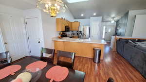 Kitchen featuring stainless steel appliances, a sink, a peninsula, open floor plan, and a chandelier