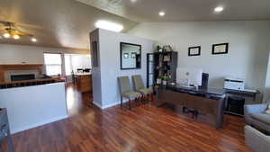 Front Living Room, wood-type flooring, lofted ceiling, a tiled fireplace, and recessed lighting