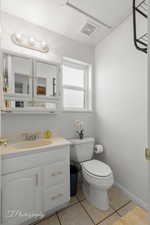 Bathroom with tile patterned floors, toilet, and vanity
