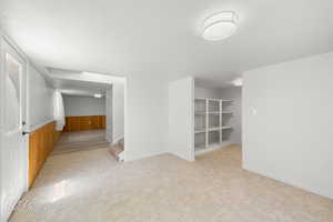 Empty room featuring wooden walls, a wainscoted wall, and stairway
