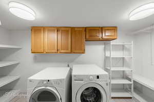 Washroom featuring cabinet space and washing machine and dryer