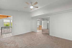Unfurnished bedroom with carpet, lofted ceiling, baseboards, ensuite bath, and a ceiling fan