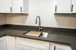 Kitchen with a sink and white cabinetry