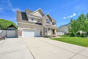 Traditional-style home with a gate, stucco siding, concrete driveway, an attached garage, and roof with shingles