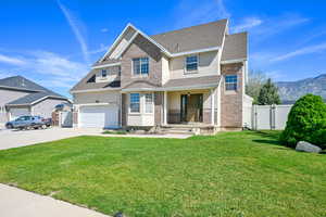 Traditional home featuring a gate, stucco siding, concrete driveway, a shingled roof, and a mountain view
