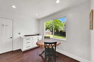 Dining room featuring dark wood-style floors, baseboards, and recessed lighting