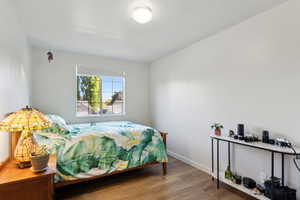 Bedroom with wood finished floors and baseboards