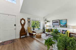 Foyer featuring high vaulted ceiling, wood finished floors, and baseboards