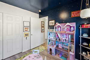 Recreation room featuring wood finished floors and baseboards