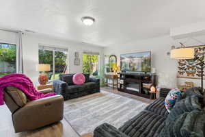 Living area featuring wood finished floors and a textured ceiling