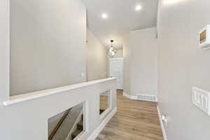 Corridor featuring baseboards, light wood-style floors, and recessed lighting
