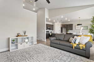 Living area featuring ceiling fan, light wood-type flooring, baseboards, recessed lighting, and high vaulted ceiling