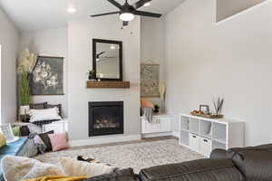 Living room with wood finished floors, ceiling fan, and a glass covered fireplace