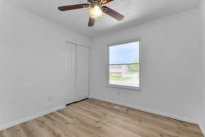 Spare room featuring baseboards, light wood-style flooring, and ceiling fan