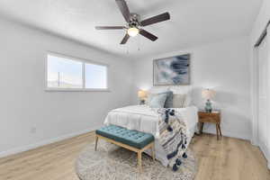 Bedroom featuring light wood-style floors, baseboards, ceiling fan, and a closet