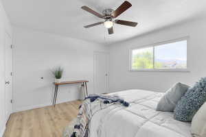 Bedroom with light wood-type flooring, baseboards, and ceiling fan