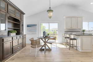 Dining room featuring light wood-style flooring and high vaulted ceiling