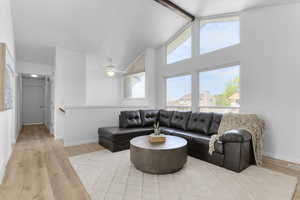 Living room with light wood-style flooring, baseboards, and a ceiling fan