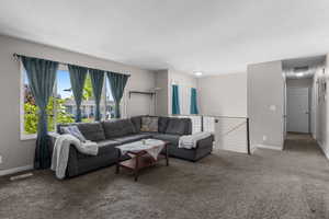 Carpeted living area featuring baseboards