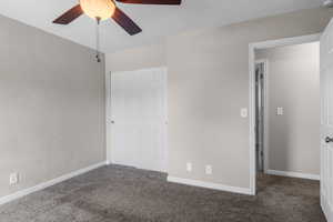 Unfurnished bedroom featuring carpet floors, baseboards, and a ceiling fan