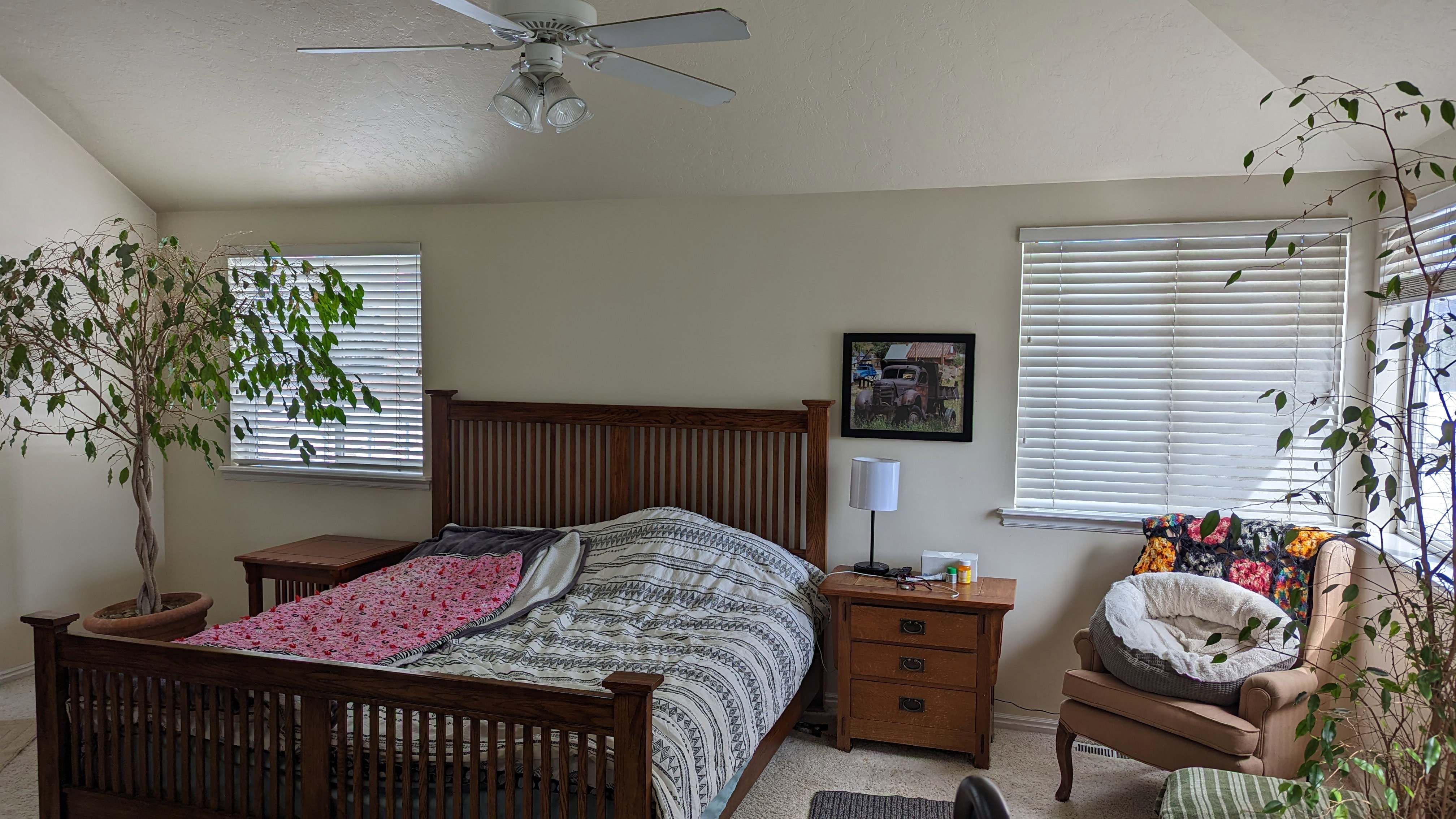 Bedroom featuring a ceiling fan, baseboards, light colored carpet, and vaulted ceiling