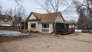 Back of house featuring fence and a shingled roof