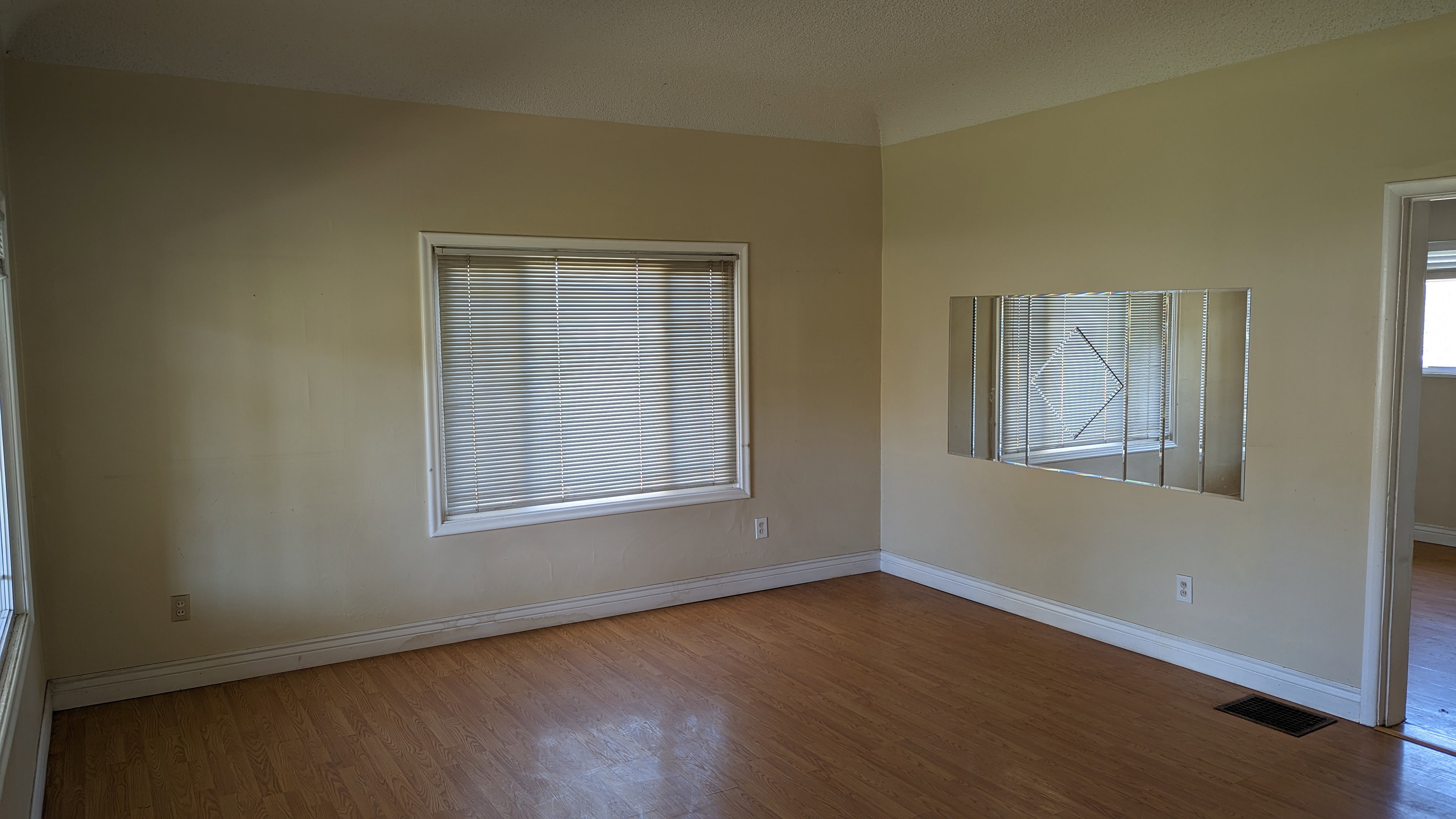 Unfurnished room with baseboards, wood finished floors, and visible vents