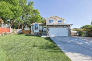 Tri-level home with concrete driveway and a garage