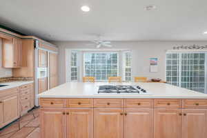 Kitchen with white gas cooktop, ceiling fan, light countertops, recessed lighting, and light tile patterned floors