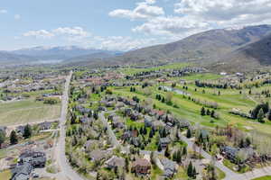 View of property location with nearby suburban area, a water and mountain view, and a local golf course