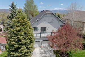 View of front facade featuring stucco siding, driveway, and a garage