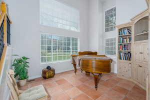 Sitting room featuring a towering ceiling, baseboards, and light tile patterned floors