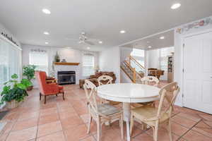 Dining room featuring recessed lighting, ceiling fan, a glass covered fireplace, and stairs