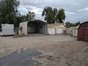 Detached garage featuring a shed and driveway