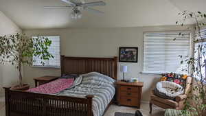 Bedroom with light colored carpet, vaulted ceiling, a ceiling fan, and baseboards