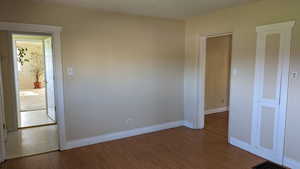 Spare room featuring wood finished floors and baseboards