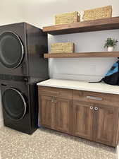 Laundry room with stacked washing machine and dryer and cabinet space
