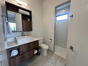 Full bath with toilet, a walk in shower, plenty of natural light, and vanity