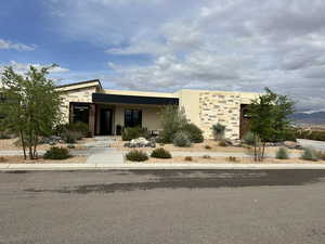 Contemporary house featuring stone siding and stucco siding