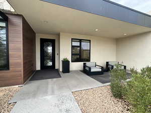 Doorway to property featuring stucco siding and a patio area