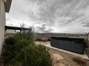 Fenced backyard featuring a hot tub
