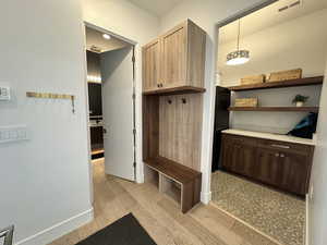Mudroom with light wood-style floors and baseboards