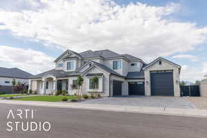 View of front of property featuring a standing seam roof, decorative driveway, fence, a garage, and metal roof
